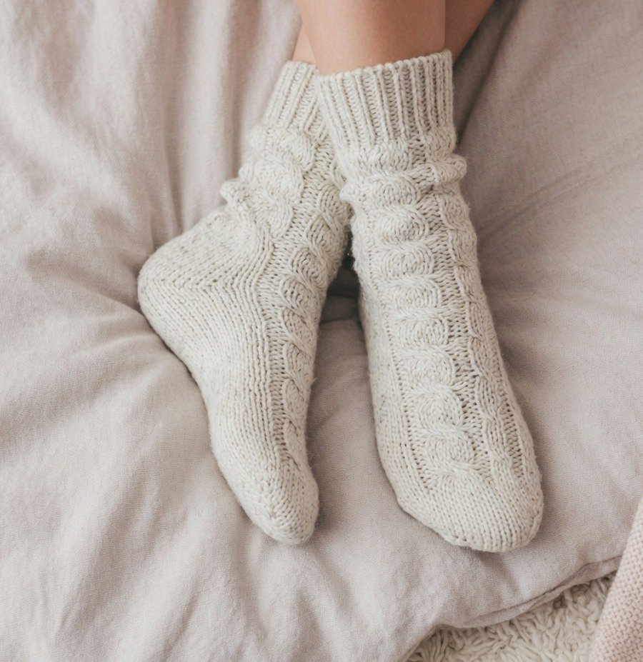 Feet in cozy knitted socks for a fully covered feet pic set